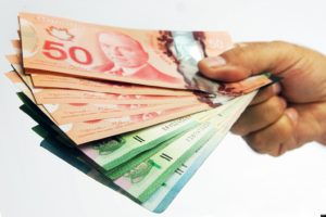 Hand holding fanned out Canadian money.The Canadian Press Images-Mario Beauregard